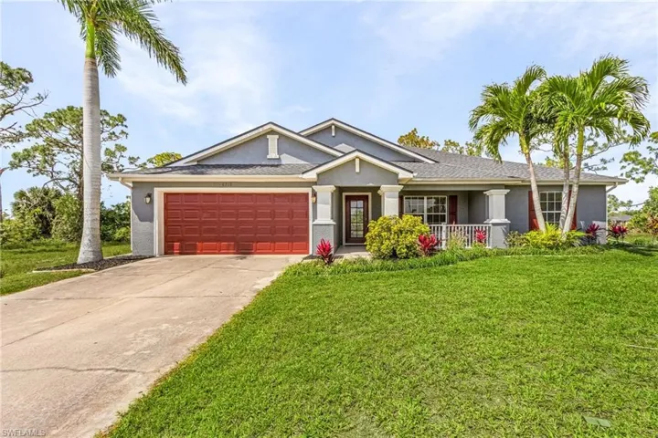 View of front of house featuring a front yard, concrete driveway and  garage