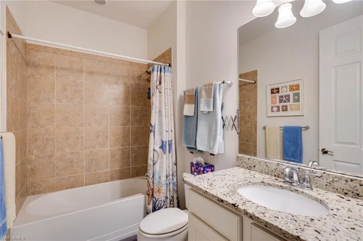 Full bathroom with shower / bath combination with curtain and vanity