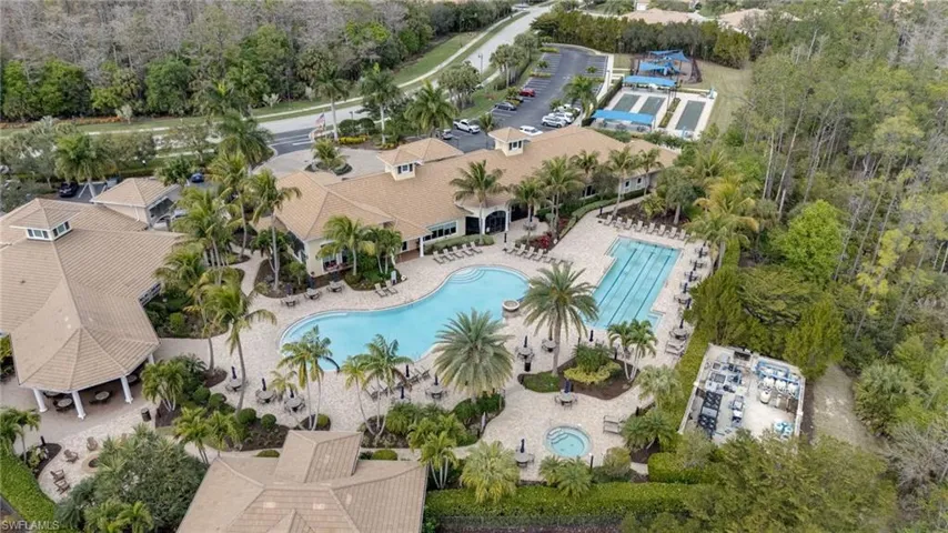 Drone / aerial view of a pool area and a tree filled landscape