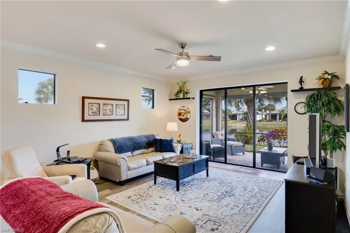 Living room with a ceiling fan, ornamental molding, wood finished floors, and recessed lighting