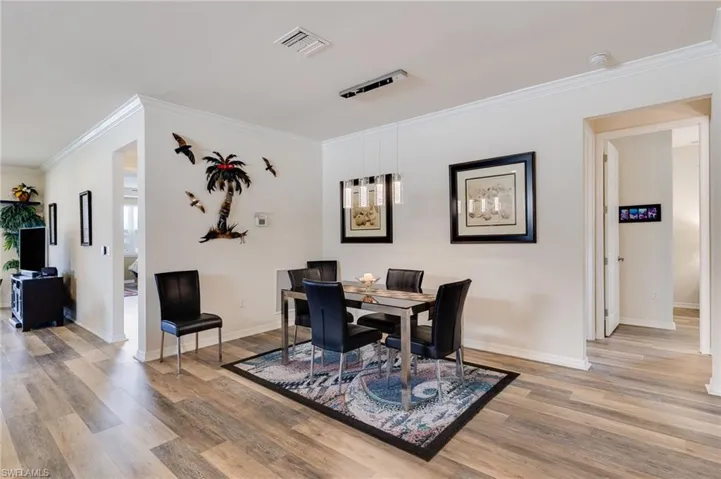 Dining space featuring ornamental molding and light wood finished floors