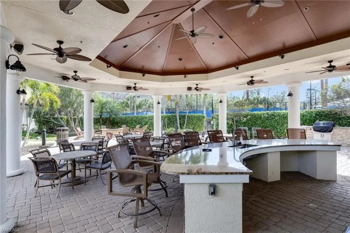 View of patio with ceiling fan, a bar, and grilling area