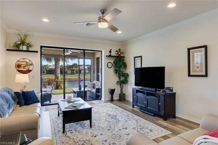 Living area featuring ceiling fan, wood finished floors, ornamental molding, and recessed lighting