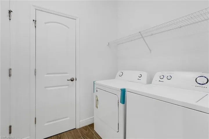 Washroom featuring washer and clothes dryer and dark wood-style floors