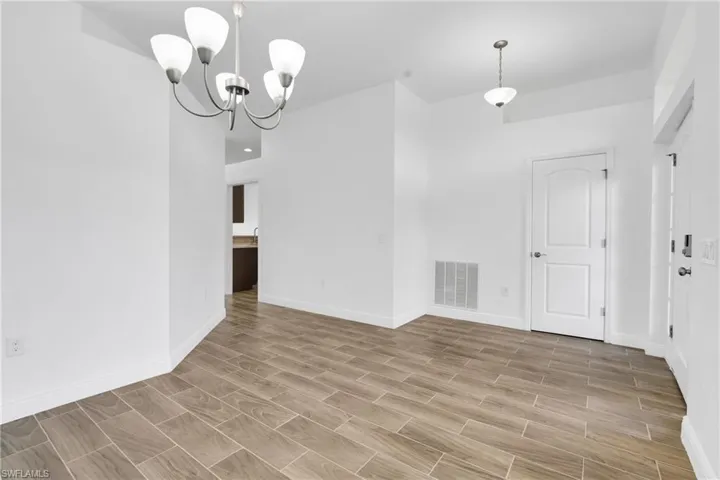 Empty room featuring a chandelier and light wood finished floors