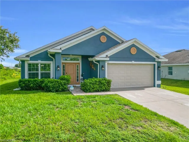 Single story home with stucco siding, an attached garage, a front yard, and concrete driveway