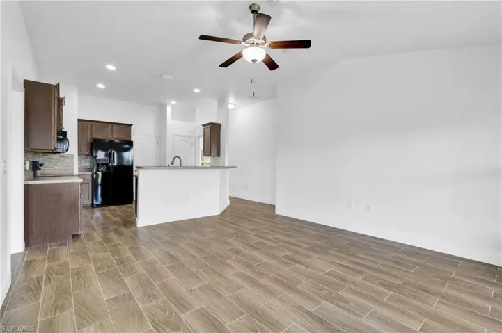 Unfurnished living room with ceiling fan, recessed lighting, light wood-type flooring, and vaulted ceiling