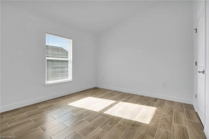 Spare room featuring wood finished floors and baseboards