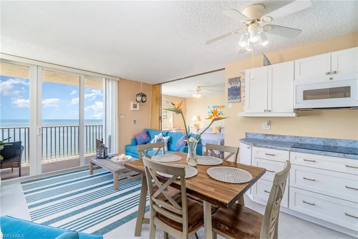 Dining space featuring a textured ceiling, ceiling fan, a water view, and light tile patterned floors