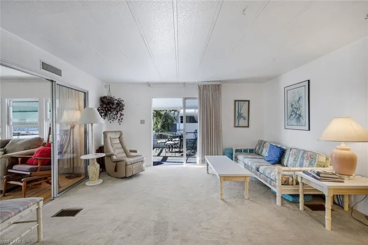 Living area with carpet and a textured ceiling