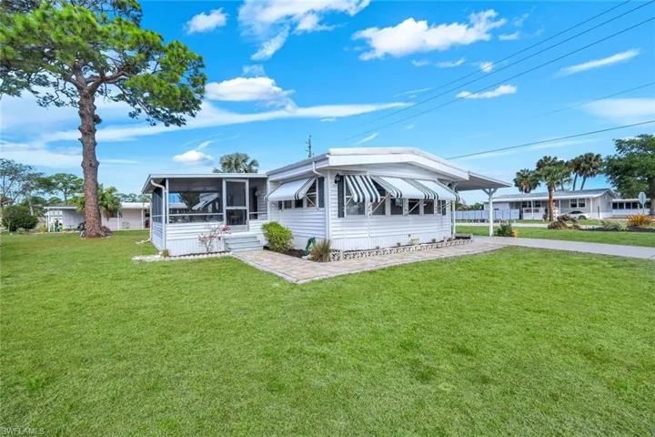 Manufactured / mobile home with a front lawn and a sunroom