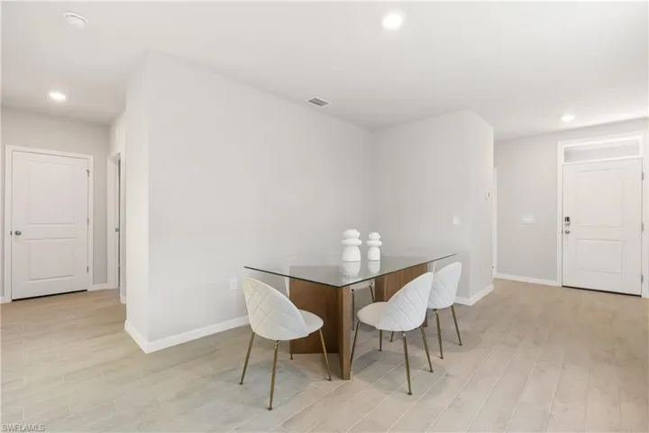 Dining room with light wood finished floors, baseboards, and recessed lighting
