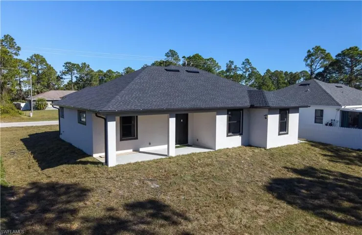 Back of property with a lawn and a patio area