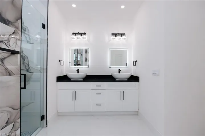 Bathroom featuring a shower with door and vanity