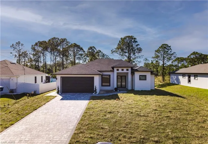 View of front of house with a garage and a front yard