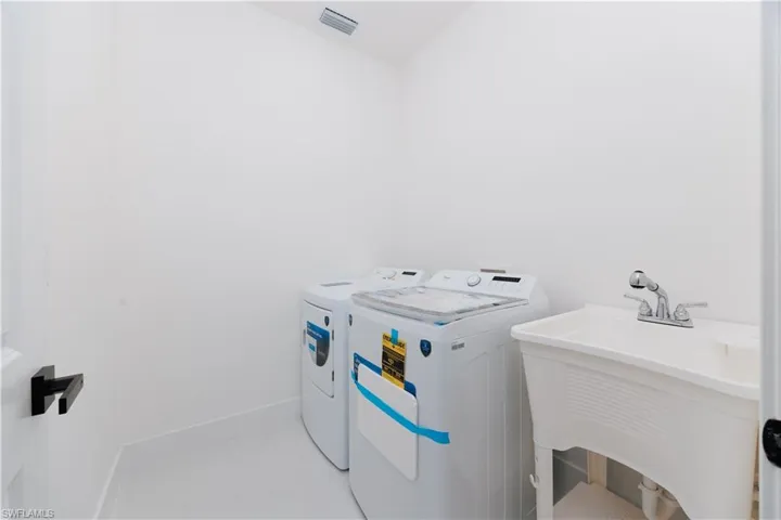 Laundry room with washer and clothes dryer and sink