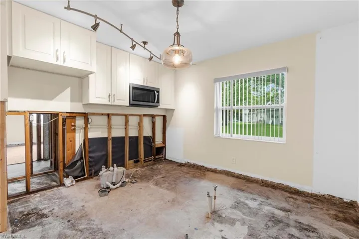 Unfurnished living room featuring concrete flooring and baseboards