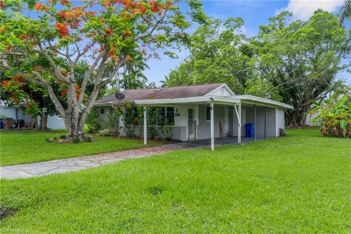 View of front of house with a front yard and an attached carport
