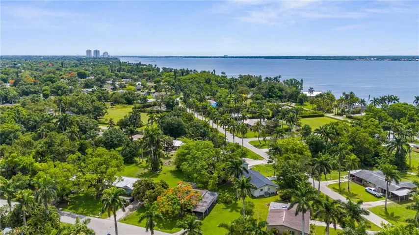 Aerial view of a nearby body of water and a tree filled landscape