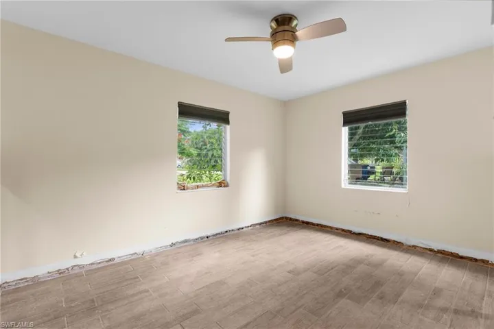 Spare room with wood finished floors, ceiling fan, and baseboards