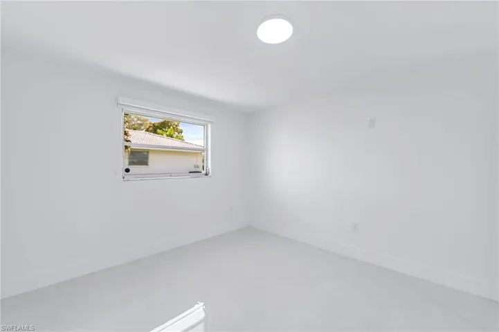 Bright room featuring a single window, recessed lighting, and light-toned flooring