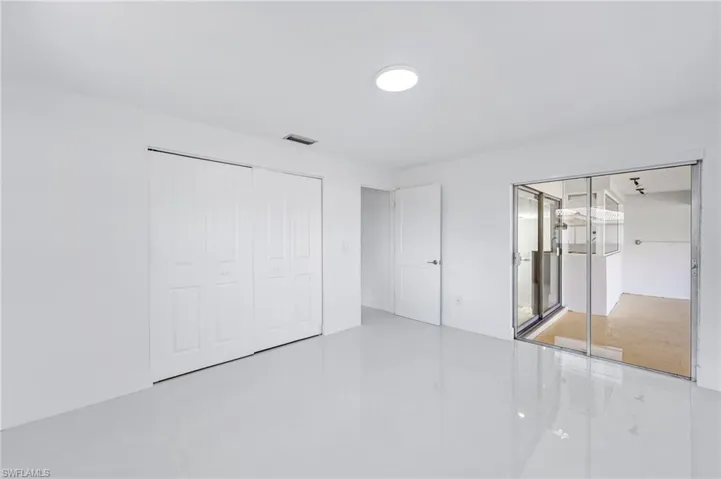Bright interior space featuring white walls and glossy white tile flooring