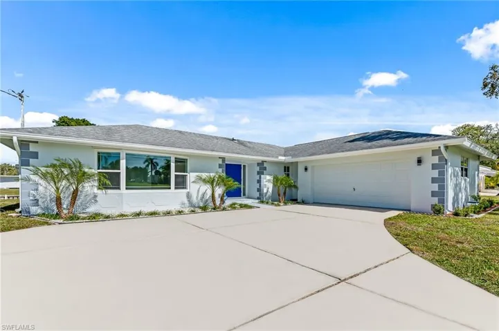 Light-colored exterior with a contrasting blue entry door and a two-car garage