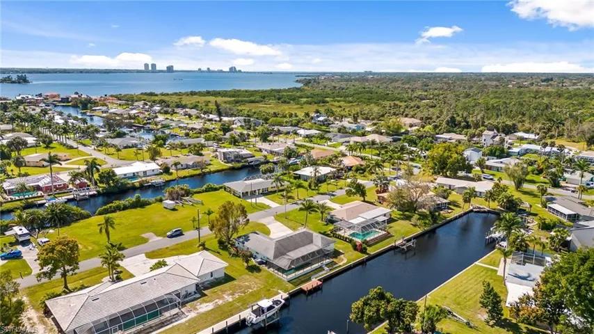 Aerial perspective of a waterfront community with direct canal access to a large body of water