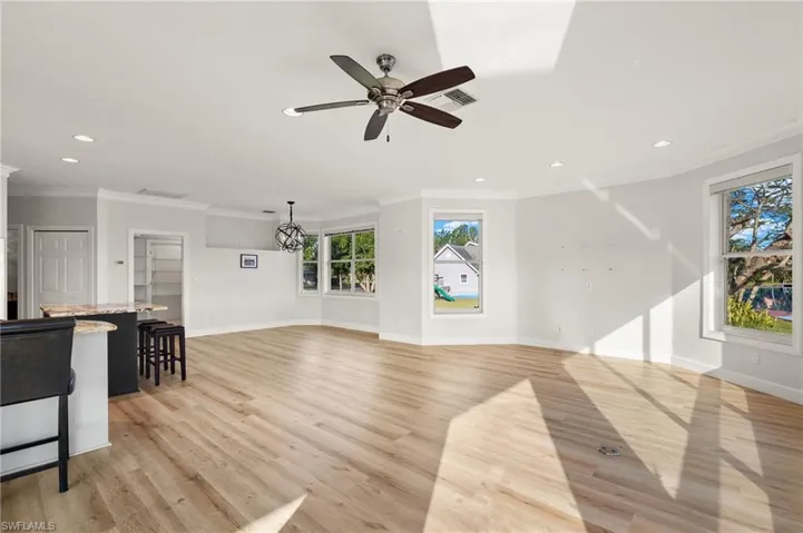 Unfurnished living room, Breakfast area, featuring ornamental molding, recessed lighting, light wood finished floors, and a ceiling fan