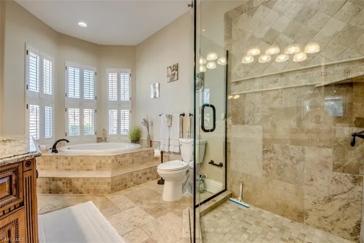 Full bathroom with plenty of natural light, toilet, shower with separate bathtub, and vanity