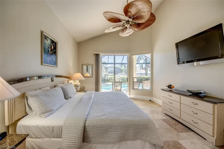 Bedroom with ceiling fan, access to outside, and vaulted ceiling