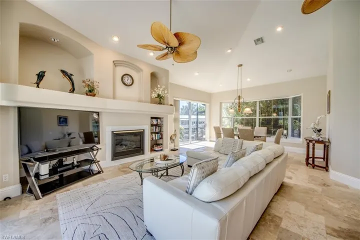 Living room featuring ceiling fan and high vaulted ceiling