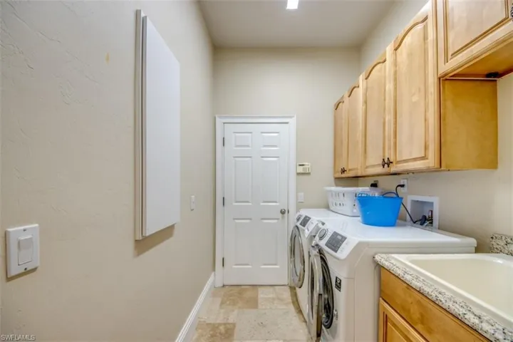 Laundry room with cabinets and washer and clothes dryer