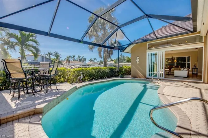 View of swimming pool featuring a lanai and a patio area