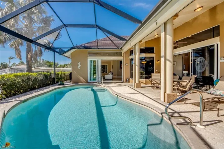 View of swimming pool with ceiling fan, a lanai, and a patio