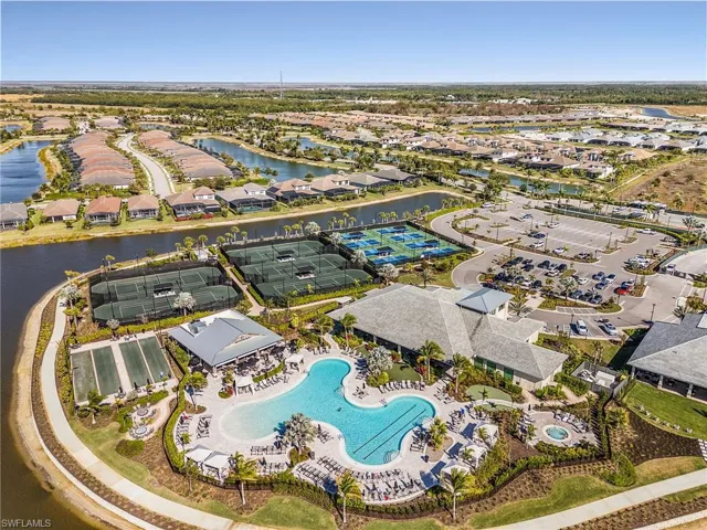 Aerial view of residential area with a large body of water and a pool area