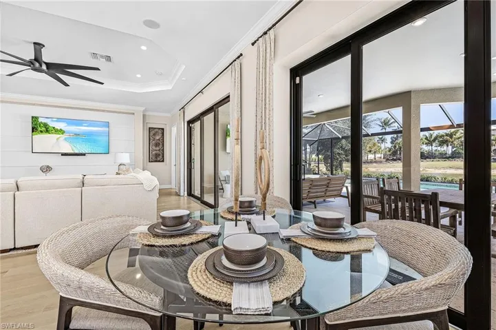 Dining space featuring a sunroom, a ceiling fan, wood finished floors, recessed lighting, and ornamental molding