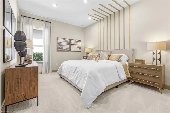 Bedroom featuring light carpet and baseboards