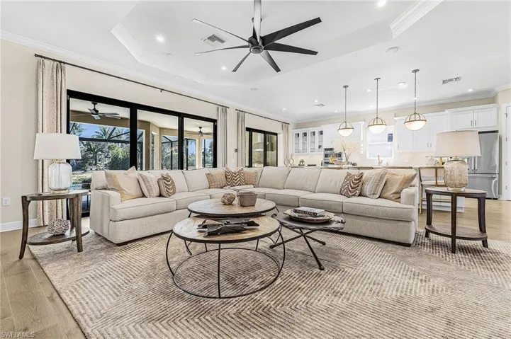 Living area featuring light wood finished floors, ornamental molding, a ceiling fan, and recessed lighting