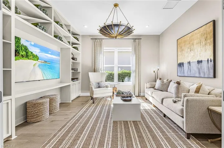 Living area with light wood-style flooring and built in shelves