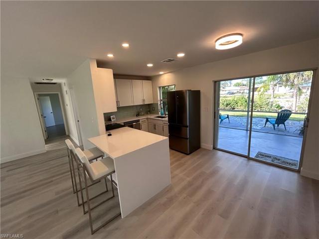 View of kitchen, lanai, patio and hallway to bedrooms