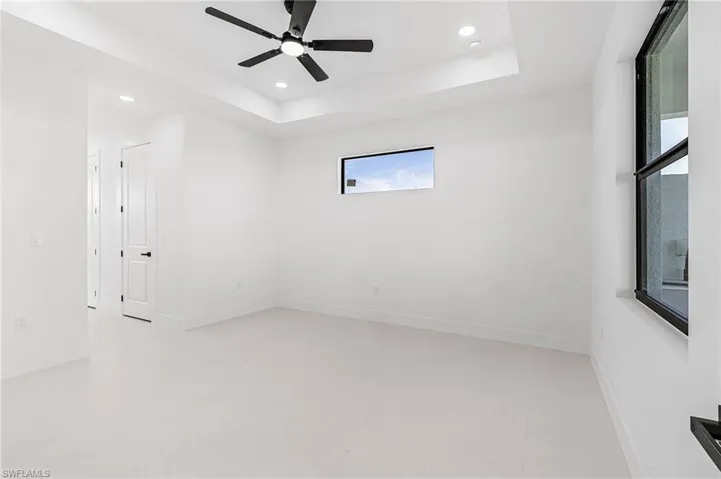 Primary Bedroom with fan and tray ceiling