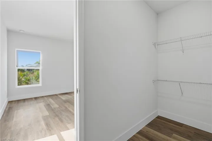 Walk in closet with light wood-style flooring