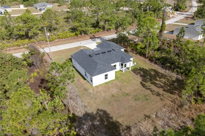 View of subject property with a tree filled landscape