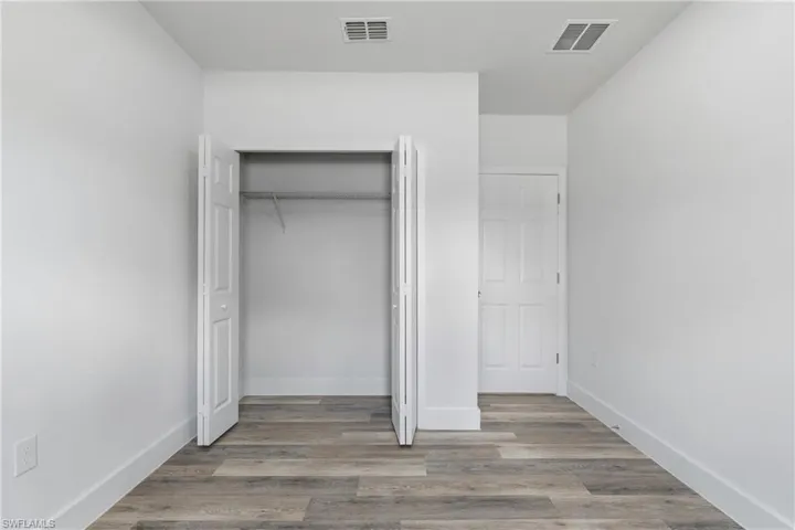 Unfurnished bedroom featuring light wood-style flooring and a closet