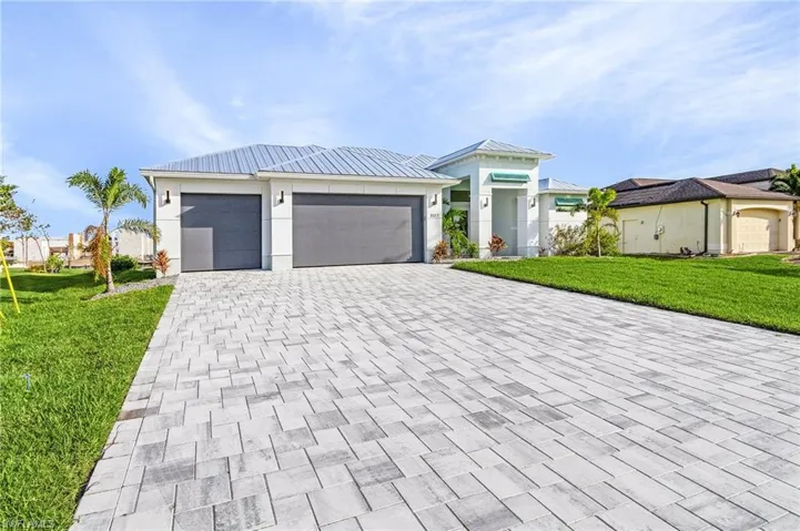 View of front of house featuring a front lawn and a garage