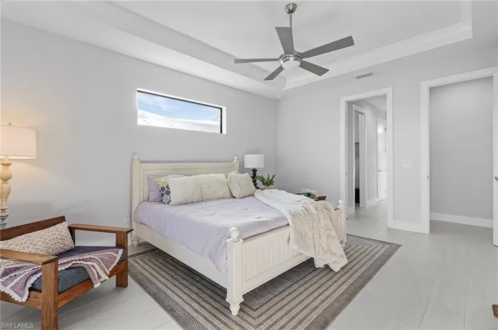 Bedroom with ceiling fan and a tray ceiling