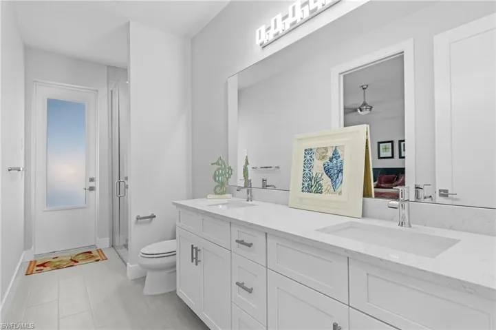 Bathroom with toilet, walk in shower, and vanity