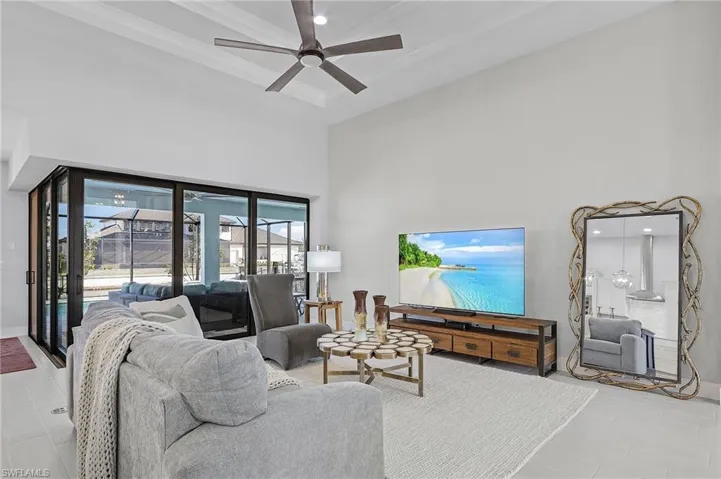 Living room featuring a towering ceiling and ceiling fan