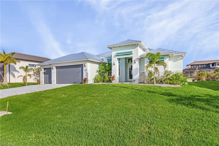 View of front of property featuring a front lawn and a garage
